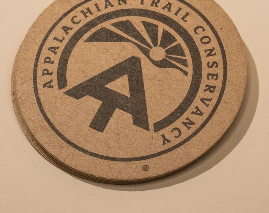 Stack of round kraft cards with a dark printed circular logo